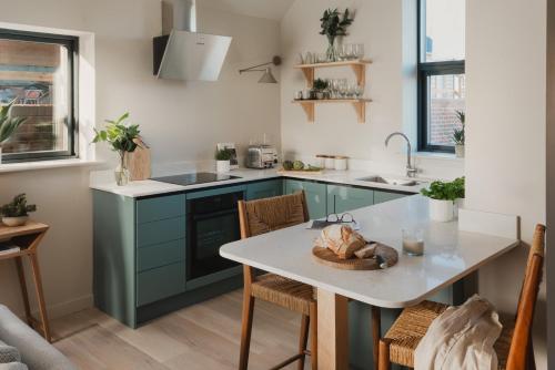 a kitchen with blue cabinets and a table with chairs at Adam in Newent
