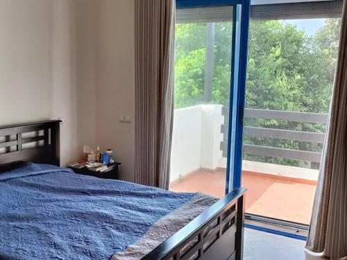 a bedroom with a bed and a large window at Appartement à 2 minutes de la plage Skhirat in Skhirat