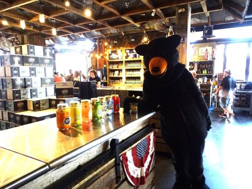 a person in a bear costume standing at a bar at Smoky Bear Splash Top Rated Private Pool Cabin with Hot Tub, Mtn Views, Arcade Games, Excellent Location in Pigeon Forge