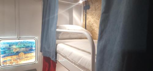 Una pequeña habitación con una cama y un espejo. en Hostel 777 Center, en Kiev
