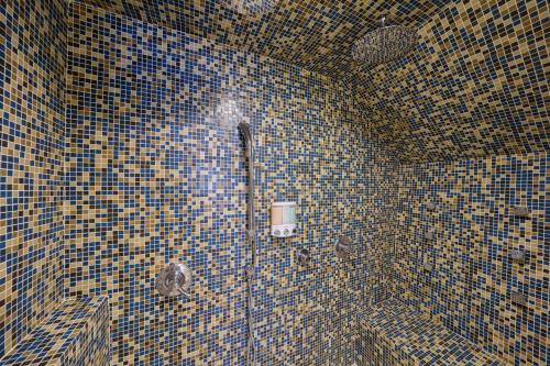 a bathroom with a tiled wall with a shower at Houston Towers Inn, Adults-Only, Downtown, Med Ctr, NRG in Houston
