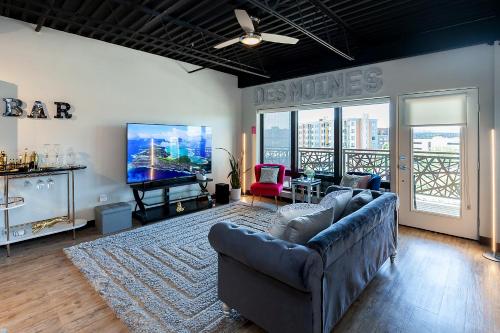 a living room with a couch and a flat screen tv at Cartier-Lux DT Unit-Skyline Views in Des Moines