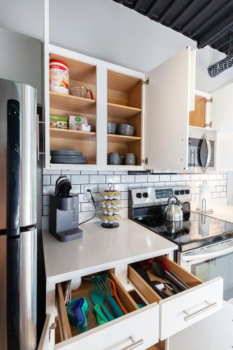 a kitchen with white cabinets with open drawers at Cartier-Lux DT Unit-Skyline Views in Des Moines