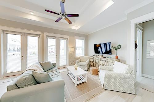 a living room with two couches and a ceiling fan at Prominence Moby Dick in Inlet Beach