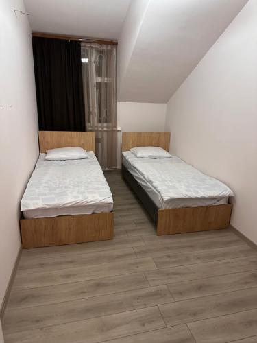 two beds in a small room with wood floors at Private house, Own and magnificent villa, Apartments in Yerevan