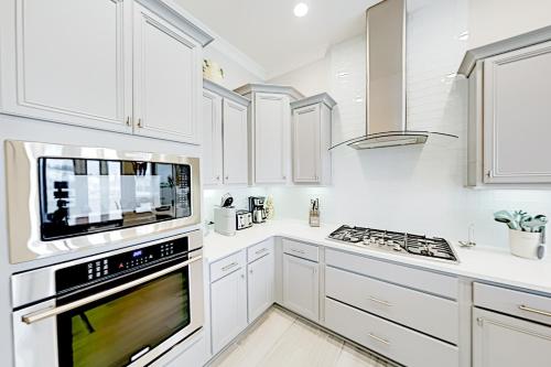 a kitchen with white cabinets and a stove top oven at Prominence Moby Dick in Inlet Beach
