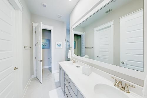 a white bathroom with a sink and a mirror at Prominence Moby Dick in Inlet Beach