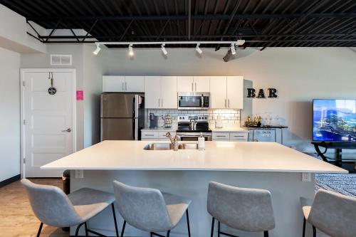 a large kitchen with a large island with chairs at Cartier-Lux DT Unit-Skyline Views in Des Moines