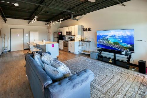 a living room with a couch and a large screen tv at Cartier-Lux DT Unit-Skyline Views in Des Moines