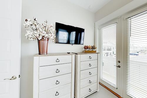 a white dresser with a vase on top of it at Prominence Moby Dick in Inlet Beach