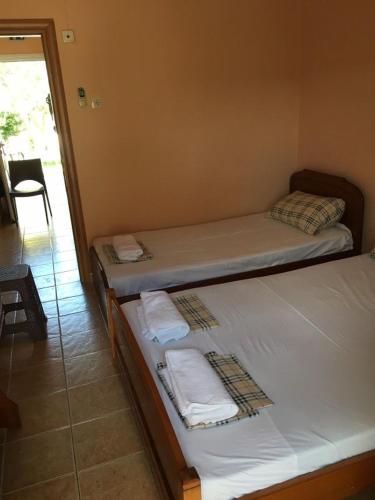 two beds in a room with towels on them at Makrygialos-Atlantis in Makrýgialos