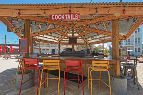 a bar with four stools under a wooden canopy at Prominence Moby Dick in Inlet Beach