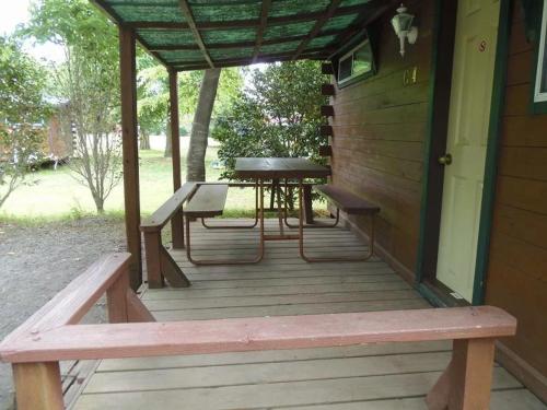 a porch with a picnic table and benches on it at Eleven Auto Camp Park - Vacation STAY 44748v in Kururi