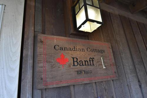 a sign on a wooden building with a canadian courthouse bank at Eleven Auto Camp Park - Vacation STAY 44750v in Kururi