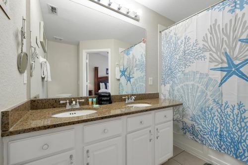 a bathroom with two sinks and a large mirror at Windsor Hills Resort - Water Park - Private Heated Plunge Pool - Near Disney in Orlando