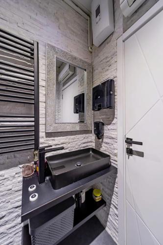 a bathroom with a black sink and a mirror at Mademoiselle Spa Apartment in Belgrade