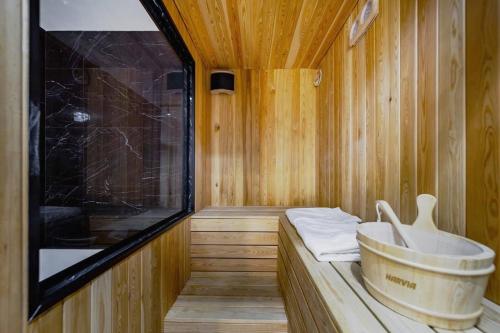 a wooden sauna with a bucket and towels in it at Mademoiselle Spa Apartment in Belgrade