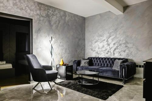 a living room with a couch and a chair at Mademoiselle Spa Apartment in Belgrade