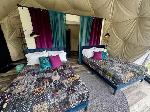 a bedroom with two beds in a tent at DayDreamer Domes in South Haven