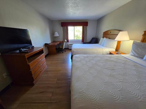 a hotel room with two beds and a flat screen tv at Fulton Hotel - Oswego Riverfront in Fulton