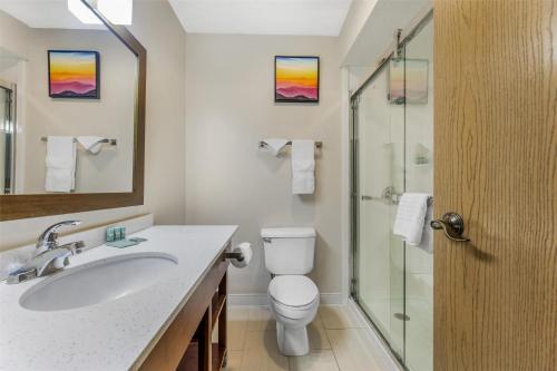 a bathroom with a toilet and a glass shower at Best Western Joliet Inn & Suites in Joliet