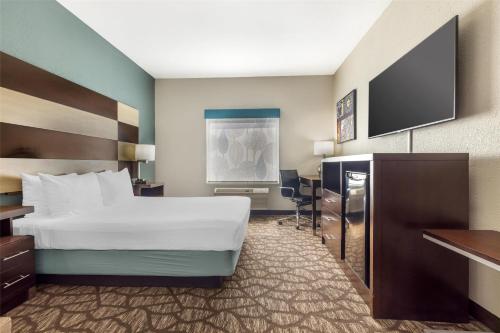 a hotel room with a bed and a flat screen tv at Best Western Joliet Inn & Suites in Joliet