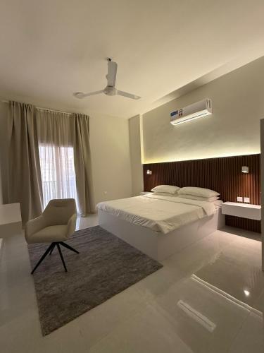 a bedroom with a bed and a chair and a window at Onyx F62-2BHK modern classy furnished home with balcony in Muscat