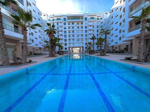 a large blue swimming pool in front of a building at La perla del Atlántico in Casablanca