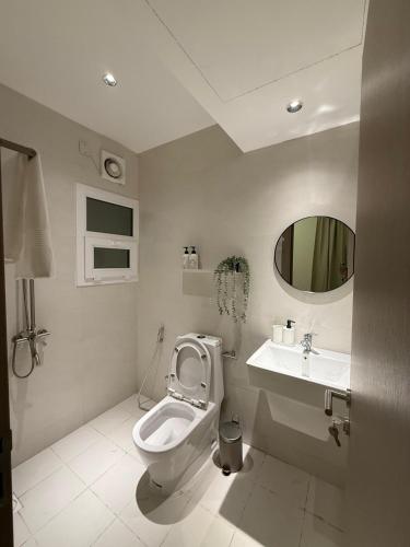 a bathroom with a toilet and a sink at Onyx F62-2BHK modern classy furnished home with balcony in Muscat