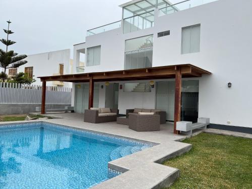 a house with a swimming pool in front of it at Acogedora casa de playa para la familia y amigos in San Antonio