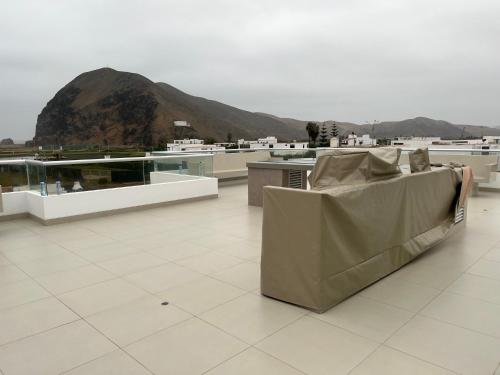 a couch on a roof with a mountain in the background at Acogedora casa de playa para la familia y amigos in San Antonio