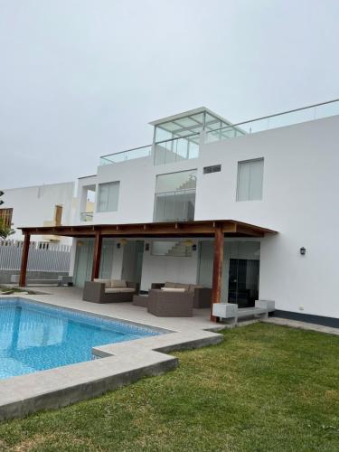 a house with a swimming pool in front of it at Acogedora casa de playa para la familia y amigos in San Antonio