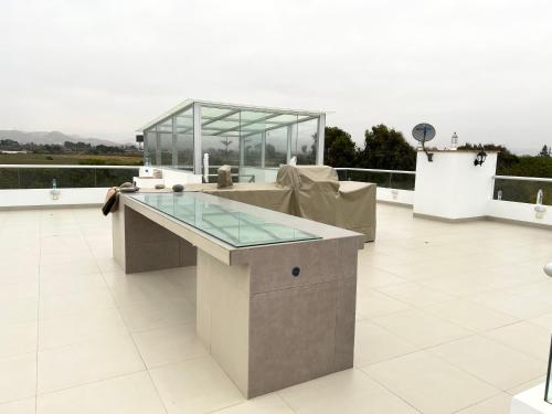a patio with a glass table on a roof at Acogedora casa de playa para la familia y amigos in San Antonio