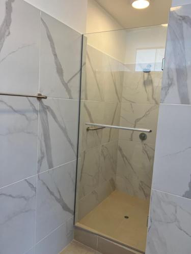 a shower with a glass door in a bathroom at Acogedora casa de playa para la familia y amigos in San Antonio