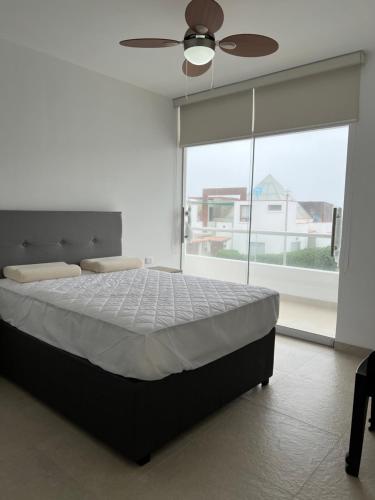 a bedroom with a bed and a ceiling fan at Acogedora casa de playa para la familia y amigos in San Antonio