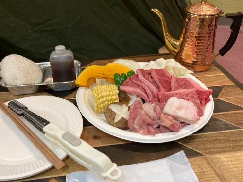 a plate of meat and vegetables on a table at MONJUNO FUKUCHI - Vacation STAY 26041v in Kamikishida