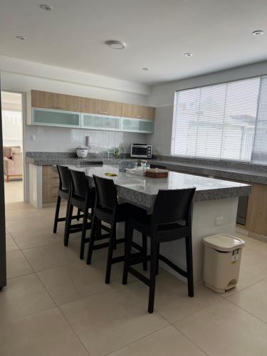 a kitchen with a large island with bar stools at Acogedora casa de playa para la familia y amigos in San Antonio