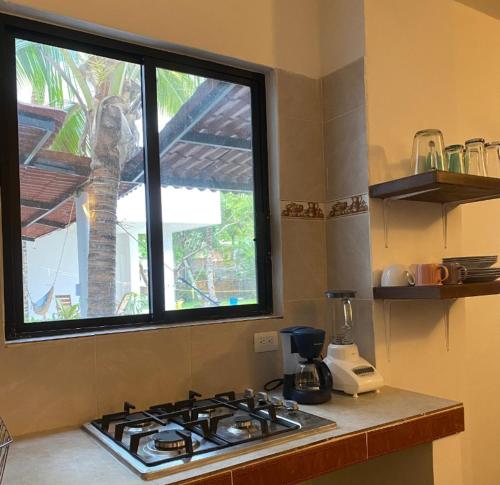 a stove top in a kitchen with a window at Costa Ayala casa para 18 personas a cuadra y media de la playa in Los Ayala