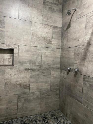 a bathroom with a shower with a stone wall at Costa Ayala casa para 18 personas a cuadra y media de la playa in Los Ayala