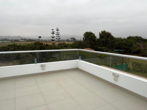 a white balcony with a view of a field at Acogedora casa de playa para la familia y amigos in San Antonio