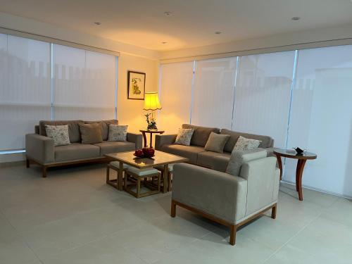 a living room with two couches and a table at Acogedora casa de playa para la familia y amigos in San Antonio