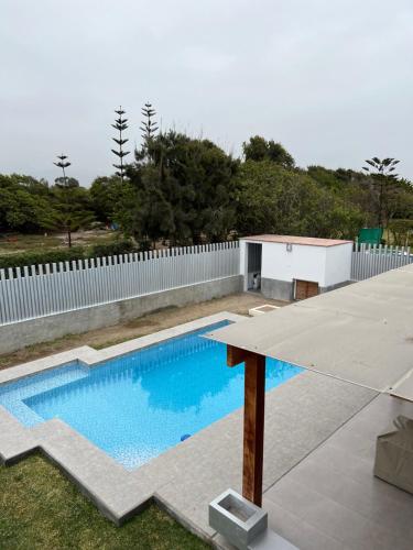 a swimming pool in a yard with a white fence at Acogedora casa de playa para la familia y amigos in San Antonio