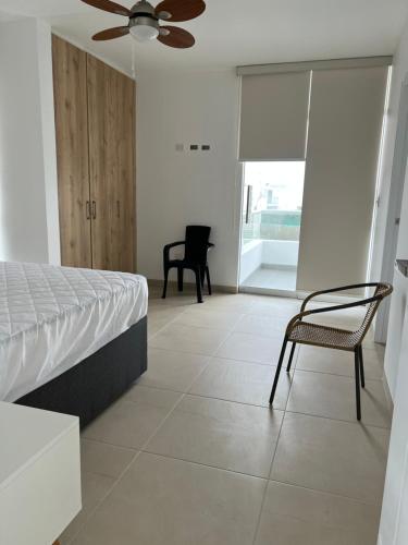 a bedroom with a bed and a chair at Acogedora casa de playa para la familia y amigos in San Antonio