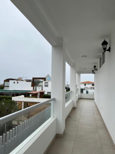 a corridor of a house with white walls and a balcony at Acogedora casa de playa para la familia y amigos in San Antonio