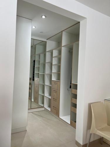 a walk in closet with white walls and a mirror at Acogedora casa de playa para la familia y amigos in San Antonio