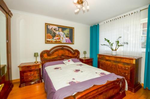 a bedroom with a bed and a painting on the wall at A Riverside Paradise in The City w Garden and Free Parking - A 2 Bed Home in London Sleeps 4! in Thamesmead