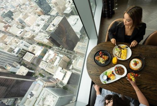 a woman sitting at a table with a plate of food at InterContinental - Los Angeles Downtown by IHG in Los Angeles