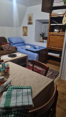 a living room with a table and a blue couch at Seoski dom in Šavnik
