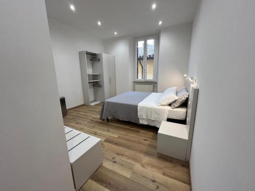 a white bedroom with a bed and a window at Pertichetti Living in Foligno