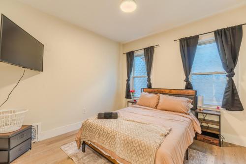 a bedroom with a bed and a flat screen tv at LUXE 4BDR2BA Near Boston- T-Station & Encore Casino in Somerville